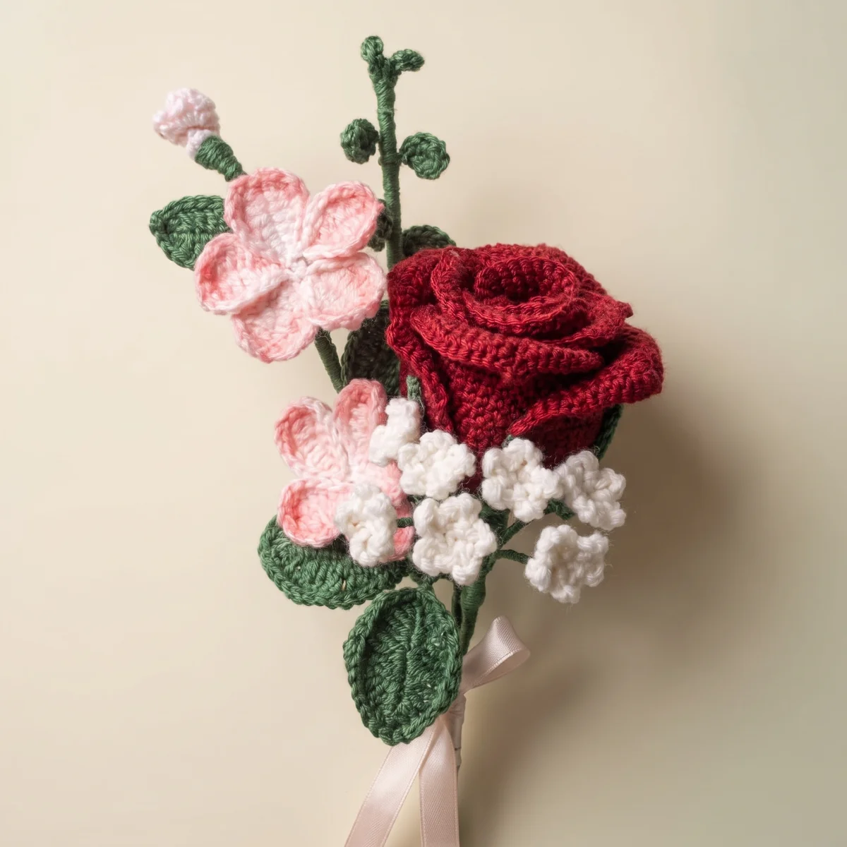 Close view of the crocheted rose and pink and white flowers